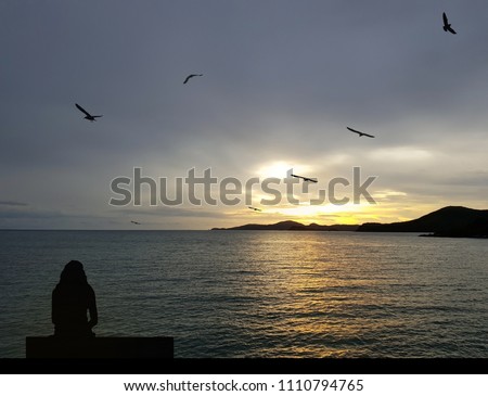 Front view of the island, blue sea - Gold And seagulls are flying. (twilight); (Here - Pattaya Thailand.
Girl sitting on a chair, on a sand beach.
Sadness, loneliness, suffering, heartbroken, lonely