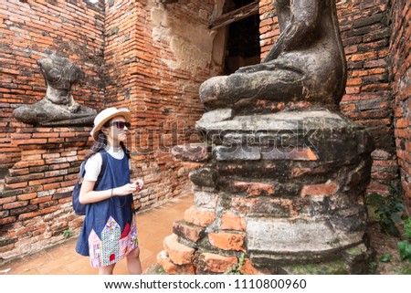 Asian girl tourist watching the beauty of ancient art, at Wat Chaiwatthanaram is a Buddhist temple in the city of Ayutthaya Historical Park,Thailand,summer vacation,travel concept.