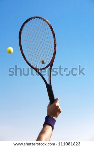 tennis racket in his hand against blue sky Royalty-Free Stock Photo #111081623