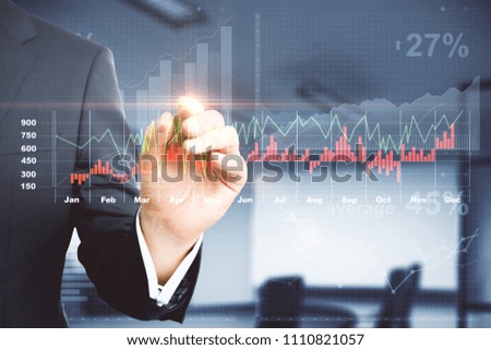 Businessman pointing at creative glowing chart on blurry office background. Fund management and trade concept. Double exposure 