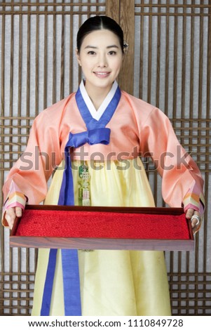 young woman in korean traditional clothing holding tray Royalty-Free Stock Photo #1110849728