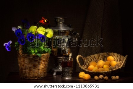 Still life with russian samovar, viola flowers and apricots.