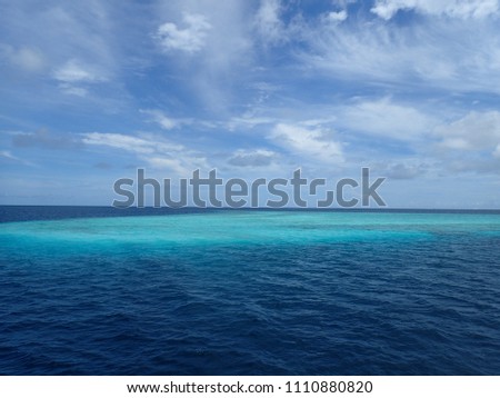 Blue,  turquoise seascape with sky background.