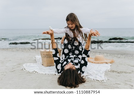 Mother and daughter holding hands and walking on beach. Mom and dauther happy family lifestyle concept