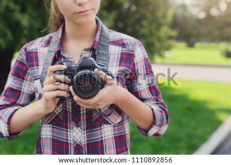 Unrecognizable woman photographing outdoors on professional camera, copy space. Taking photos and photography classes concept