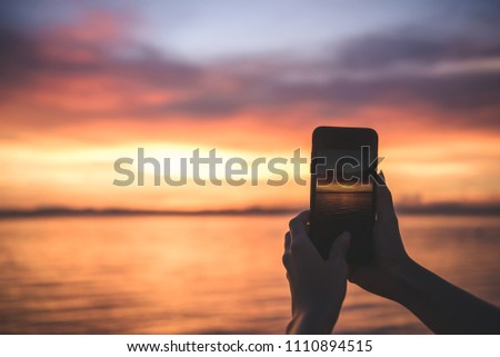 people take a photo of  dramatic sky sunset time golden hour