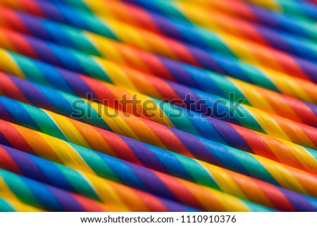 Colorful paper cocktails straws in row abstract background