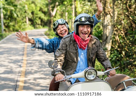 Senior couple riding a classic scooter Royalty-Free Stock Photo #1110917186