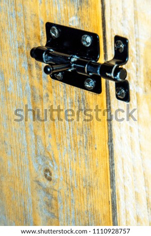 locking on a wooden surface to close the access to the space behind it