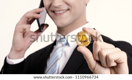 Crop image of Successful Handsome young businessman in suit with mobile phone and bitcoin. Attractive business man on white background.
