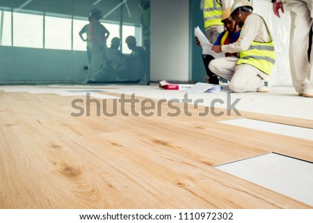 Installing wooden laminate flooring Royalty-Free Stock Photo #1110972302