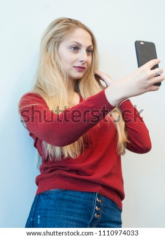 Beautiful girl taking pictures of herself on the phone. Self.
