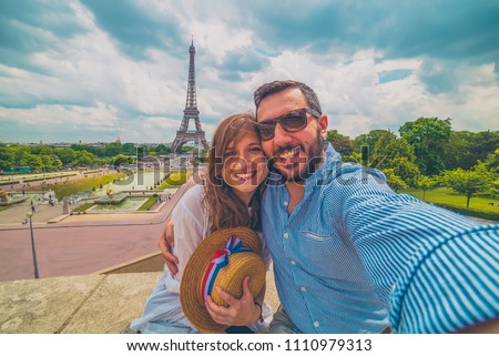 Happy couple in paris, France. Handsome tourist with hat with french flag taking picture selfie traveling in Europe