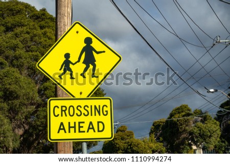 Sign of children crossing ahead erected on roadside to warn drivers for safety. Melbourne VIC Australia.