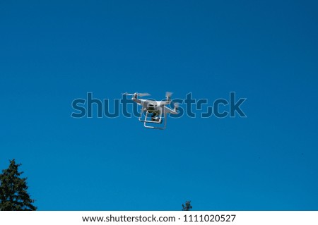White quadrupter with propellers flies in the sky and photographs landscapes