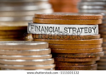 Photo of stacks and rows of coins with FINANCIAL STRATEGY concept related words imprinted on metal surface