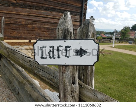 sign that says cafe with arrow on wood post