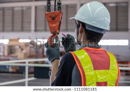 Engineers are inspecting hooks for lifting safety crane steel In the factory auto parts license Crane Operation Royalty-Free Stock Photo #1111081181