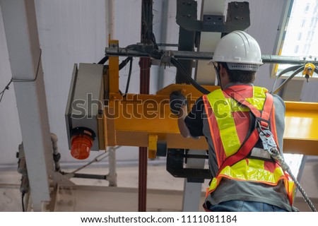 Engineers are inspecting hooks for lifting safety crane steel In the factory auto parts license Crane Operation Royalty-Free Stock Photo #1111081184