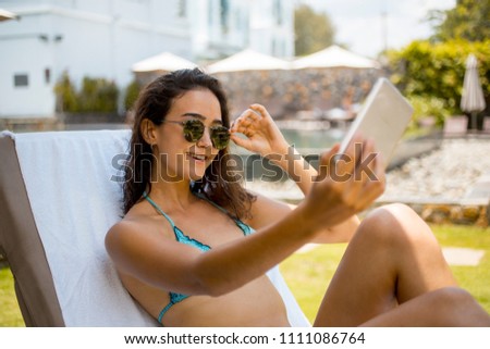 Young woman wearing sunglasses making selfie portrait