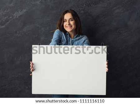 Happy young woman holding white blank banner. Excited girl showing paper sheet for sales advertisement, copy space. Commercial ad mockup