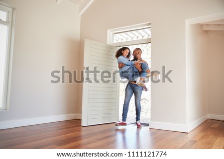 Man Carrying Woman Over Threshold Of Doorway In New Home Royalty-Free Stock Photo #1111121774