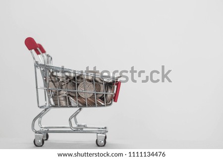 Coins in shopping cart on white background, About Finance and profitability. Royalty-Free Stock Photo #1111134476