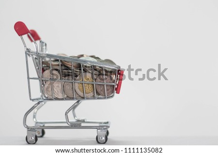 Coins in shopping cart on white background, About Finance and profitability. Royalty-Free Stock Photo #1111135082