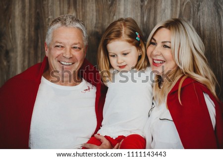 Mom and dad hold their little daughter on their hands