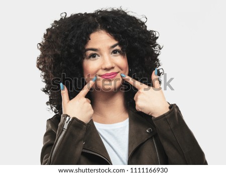 young woman pointing to her smile