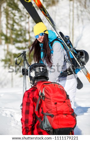 Photo of man from back and women with mountain skis walking on snow hill