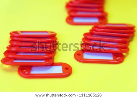 red tags without inscriptions on a yellow background, stacked in piles of three pieces