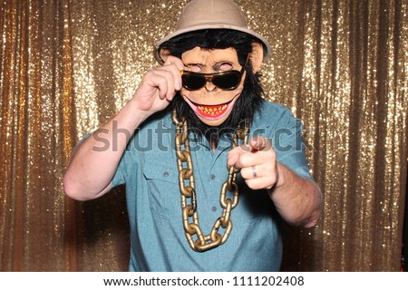 Man in a Rubber Monkey Mask while in a Photo Booth at a party or wedding.