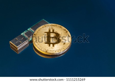 Coin of crypto currency, bitcoin, flash drive on a dark background. The concept of accumulation of funds