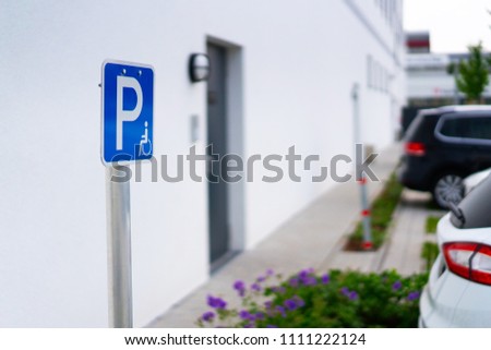 blue disabled parking badge with white wall background