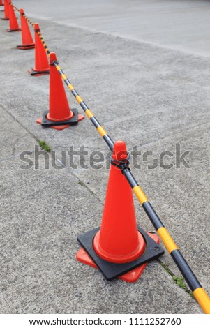 row of orange fluorescent, reflex traffic cones on road