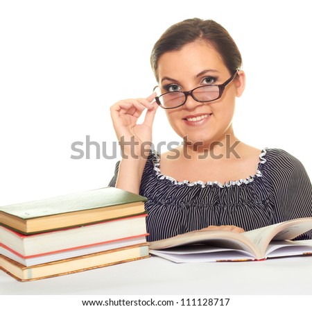 Attractive smiling girl in a black blouse with glasses reading a book isolated on white background