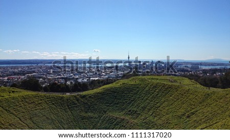 Massive green volcano crater in Auckland city New Zealand with view above the skyline and the sky tower