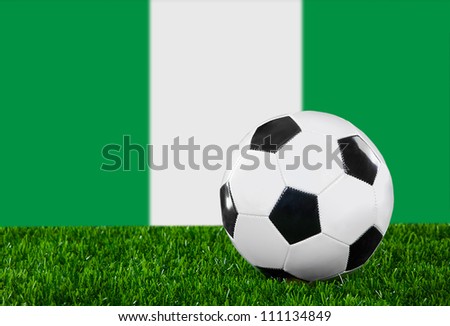 The Nigerian flag and soccer ball on the green grass