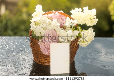 Bouquet of flowers in a basket with isolated blank paper