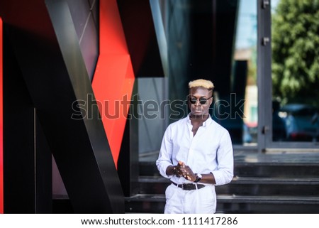 Confident businessman. Confident young afro american man standing outdoors with modern city