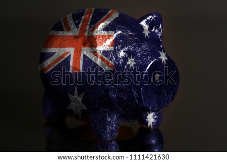 Piggy bank with IFlag of Australia on a black background.