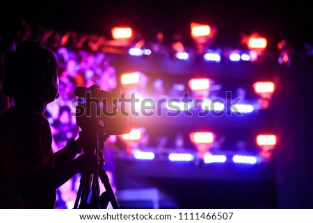 Cameraman shooting recording video in concert music festival