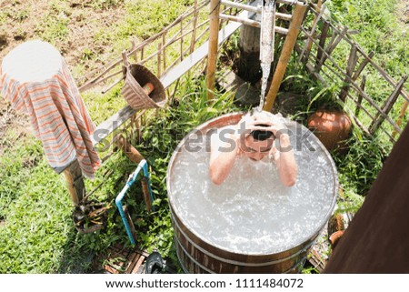Man Bathing in a Wooden Bathtub. shower open air.