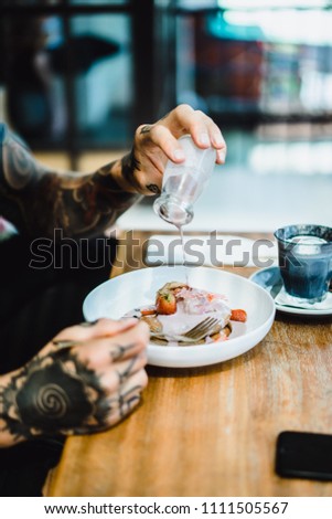 Men's hands pour pancakes with sweet sauce