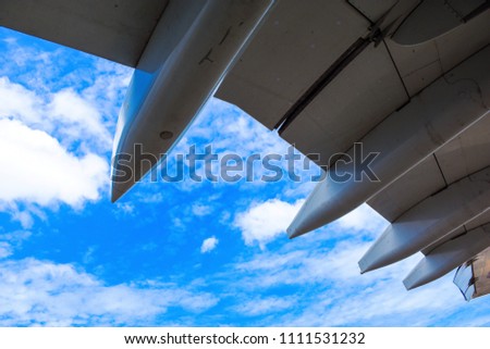 The airplane wing view from under wing with blue sky and cloudy.View Out Of Airplane Wing In Flight .  
