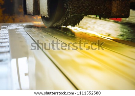 Grinding of metal on a flat machine tool with water cooling. Metalworking industry. Picture with tint.