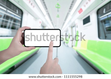 Blank screen smartphone in man hands at railway or subway