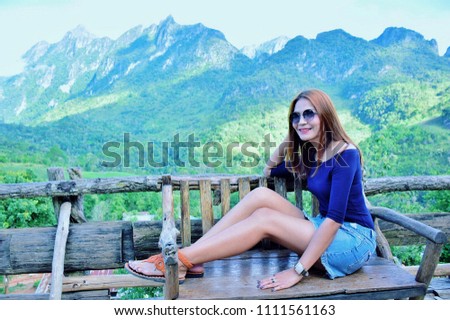 Asian girl sitting on a wooden chair in the nature with Mountain view in the winter of Thailand at Ban rabiang dao homestay, Doi Luang Chiang Dao, Fang, Chiang Mai, Thailand