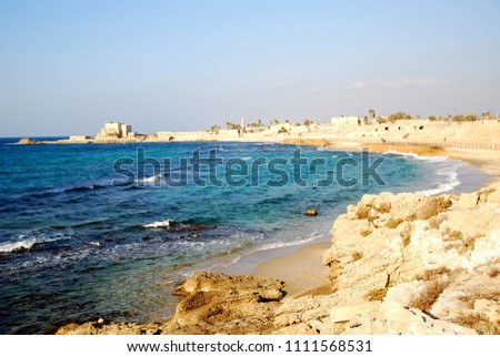Summer, sea, beach, old city, waves on the shore, ancient buildings, seagulls, sky. Mediterranean Sea, coast of Caesarea, Israel. Royalty-Free Stock Photo #1111568531